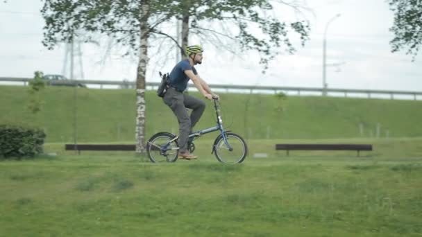 Hombre en bicicleta a caballo al parque con la tableta — Vídeo de stock