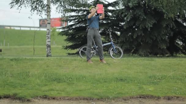 Hombre haciendo foto con la tableta en el parque — Vídeo de stock