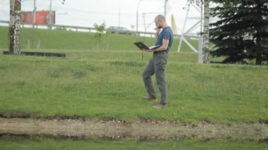 Göl karşı dizüstü bilgisayar ile konuşmaya mutlu olgun adam