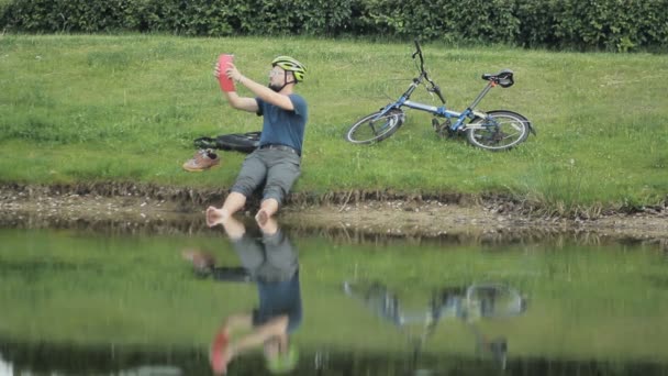 Happy mogen man med tablett mot sjön — Stockvideo