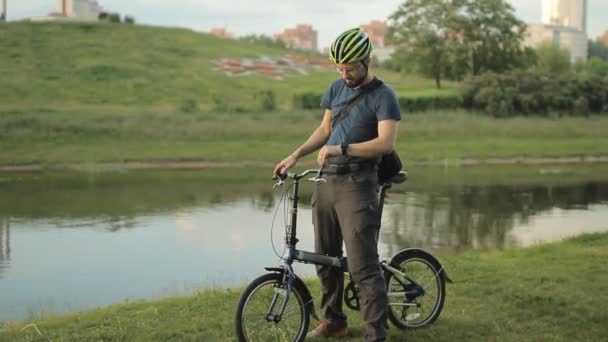 Hombre en bicicleta plegable con smartwatch — Vídeos de Stock