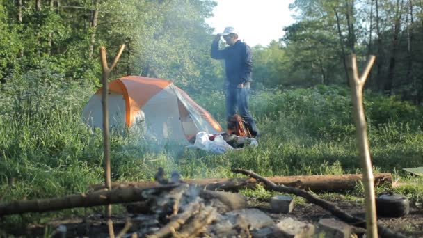 Man close tent near campfire — Stock Video