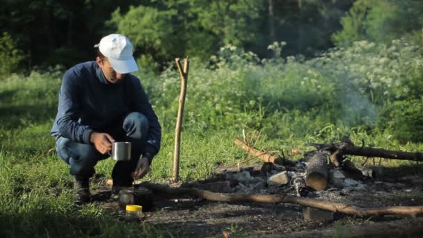 Adam içki fincan çay nea kamp ateşi — Stok video