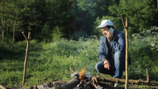 Chamada de homem por smartphone no acampamento — Vídeo de Stock