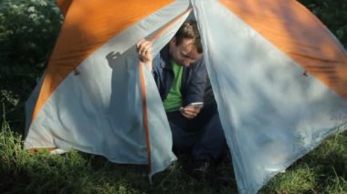 Adam çadırı açar, telefonda birkaç fotoğraf çeker ve çadırı kapatır.