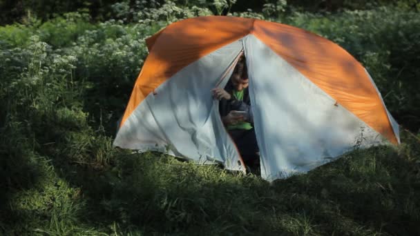 Der Mann öffnet das Zelt, macht ein paar Fotos am Telefon und schließt das Zelt — Stockvideo