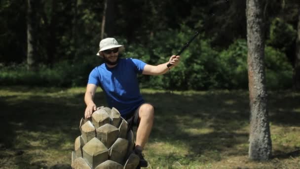 Чоловік піднімається на великий дерев'яний конус і стріляє в камеру дій — стокове відео