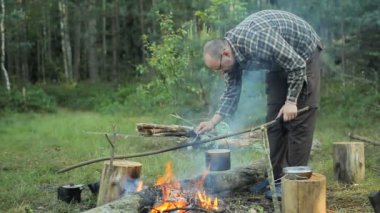 Bir tencerede kaynar su yanıyor. Bir adam pislik kaldırır ve sokağa atıyor
