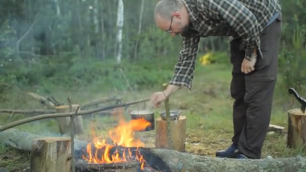 Adam yemek pot ile çalışır. Pot kampında lezzetli yemek hazırlanıyor — Stok video