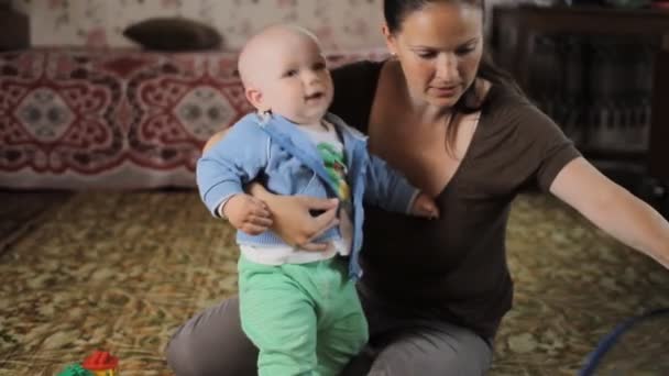 Um miúdo lindo não ouve a minha mãe em casa. Ele tinha menos de um ano e tenta fugir dela. — Vídeo de Stock