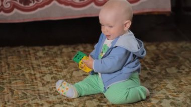Evde oyuncaklarla oynayan bebek. Yakışıklı çocuk bir yıldan az