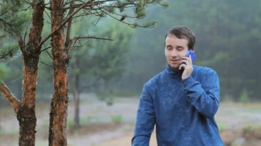 Bir adam telefonda ormandaki bir ağaç yakınındaki arıyor. Sabah erken