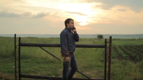 Man calling on the smart phone. Beautiful sunset on the background — Stock Video