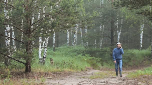 Чоловік гуляє лісом і телефонує рано вранці — стокове відео