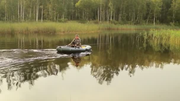 Homme pêcheur flotte sur un lac sur un bateau gonflable. Tôt le matin — Video