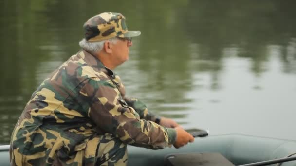 Un homme travaillant sur un ordinateur portable sur le lac. Un pêcheur avec une canne à pêche — Video