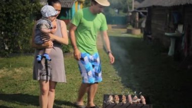 Çocuk babası ve annesi ateş üzerinde et pişirmek. Barbekü hazır sayılır