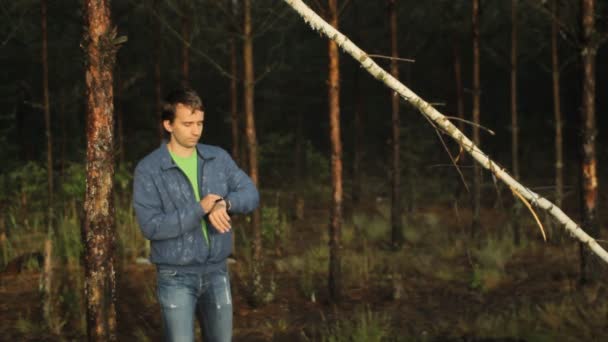 Un homme touchant des smartwatches dans la forêt. Tôt le matin — Video