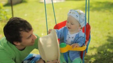 Salıncak ile oynarken onun şirin bebek çocuk ile mutlu baba
