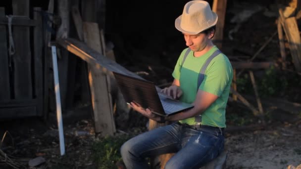 Young man making video call at the sawmill with laptop computer in his hands — Stock Video