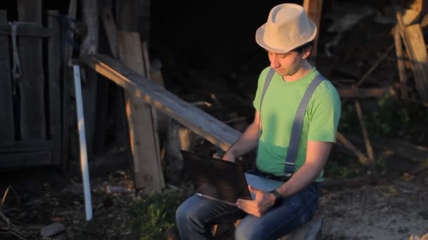 Young man making video call at the sawmill with laptop computer in his hands — Stock Video