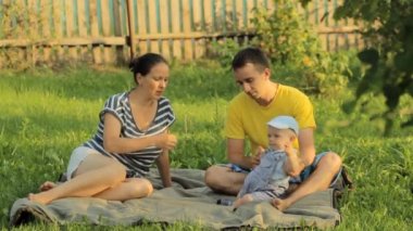Üç yaz parkta çim yalan mutlu aile. Onlar oyun ve gülümseme