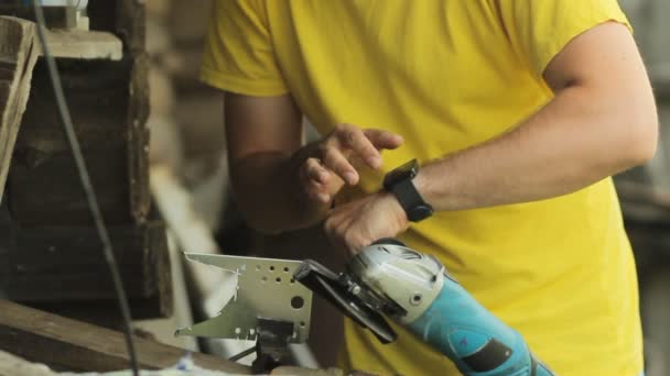 En man som arbetar på en smart klocka, sätter åt sidan smartwatch och börjar såga metall med angule kvarn. Flygande gnistor — Stockvideo