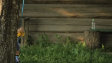 Şirin bebek çocuk salıncak yaz bahçesinde oynarken. Salıncaklar ağaca bağlı olan