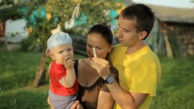 Mutlu bir aile clothespins ile bahçede oynarken. Anne, baba, oğul, gülümseme ve gülmek