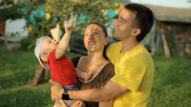 Familia feliz jugando en el jardín con pinzas de ropa. Mamá, papá, hijo, sonríe y ríe — Vídeos de Stock