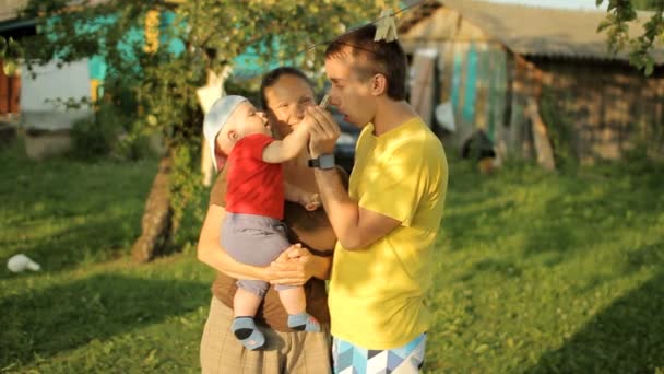 Gelukkige familie spelen in de tuin met wasknijpers. Moeder, vader, zoon, glimlach en lach — Stockvideo