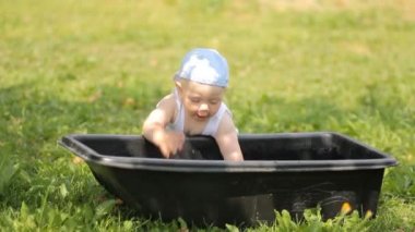 Çok güzel çocuk bahçede su Havzası ile oynarken. O kadar alır ve gülümsüyor
