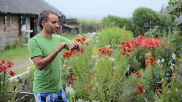 Молодий чоловік перевіряє повідомлення на розумних годинниках під дощем. Водонепроникний розумний годинник працює вниз — стокове відео