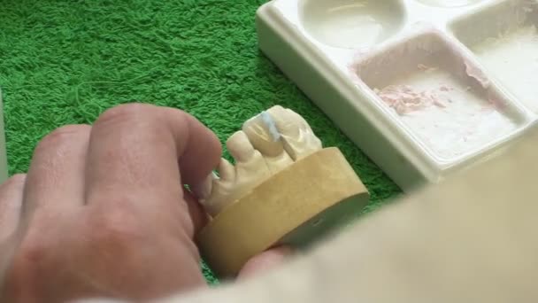 Стоматолог работает с керамическим материалом, щеткой и зубными протезами. Рабочий зубной техник. Закрыть — стоковое видео