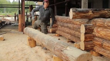 Adam ışın chainsaw gelecekteki ev için sunmaktadır. Ahşap bir yapı inşaat işleri