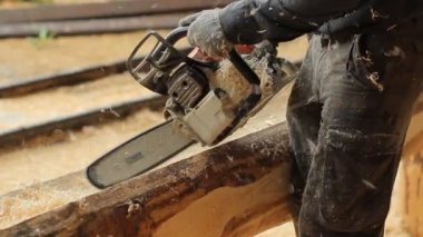 Adam ışın chainsaw gelecekteki ev için sunmaktadır. İnşaat ahşap yapısı ile çalışır. Yakın çekim