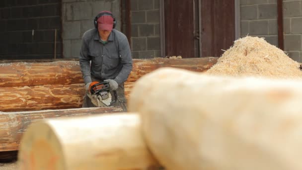 O homem corta a motosserra para o futuro lar. Obras de construção com estrutura de madeira — Vídeo de Stock