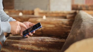 Ahşap önünde genç adam orman mühendisi dokunmatik telefon