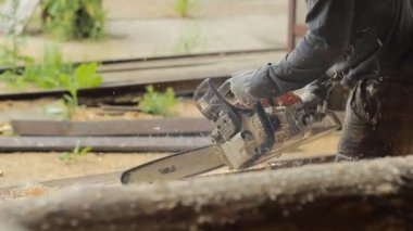 Adam ışın chainsaw gelecekteki ev için sunmaktadır. İnşaat ahşap yapısı ile çalışır. Yakın çekim