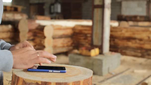 Ung man skogsbruk ingenjör beröring telefonerna framför trä — Stockvideo