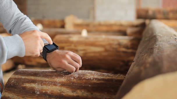 Jonge man bosbouw ingenieur touch slimme horloge voor hout — Stockvideo