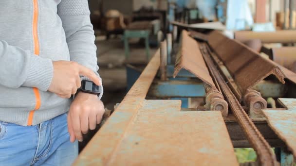 Main masculine tient un téléphone à écran tactile moderne et image floue de l'ancienne usine — Video