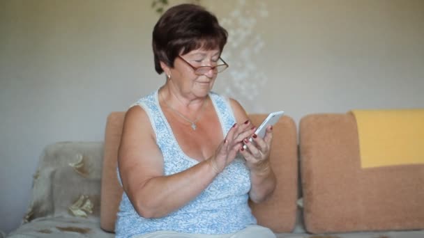 Seniorin nutzt Smartphone zu Hause — Stockvideo