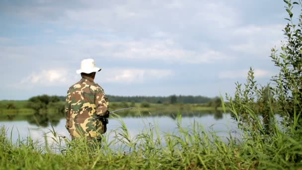 Fisher hombre con caña de pescar la captura de peces en el lago — Vídeos de Stock