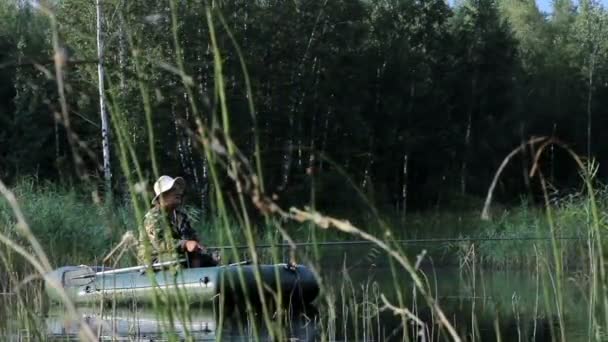 Il pescatore galleggia sul fiume su una barca gonfiabile. Mattina presto con nebbia sull'acqua. Attività in natura — Video Stock