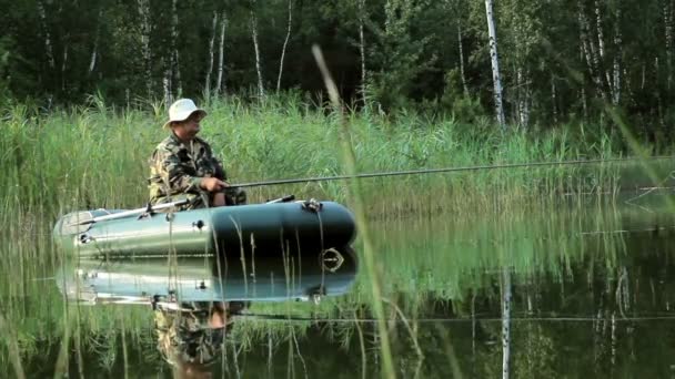 Le pêcheur flotte sur la rivière dans un bateau gonflable. Caméra mobile par curseur. Activités dans la nature — Video