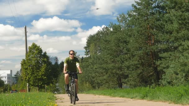 Male cyclist riding on the track. Helicopter flying in the sky. Epic shot: slow motion — Stock Video