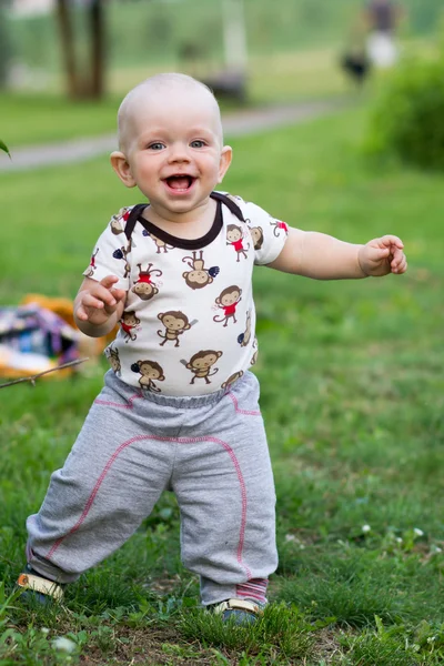 Lindo niño jugando y riendo en el parque. El verano es alrededor de un montón de vegetación cosas interesantes para migajas. Niño 1 año — Foto de Stock