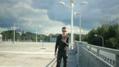 Bir adam sokakta yürüyor ve bir tablet bilgisayar ile etrafına bakıyor. Elektronik haritalar tarafından doğru sokağa bakıyor. Arka planda bir fırtına öncesi güzel gökyüzü