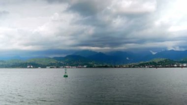 Güzel manzara: Pasifik Okyanusu'nun küçük dalgaları, uzaktaki dağlar ve yağmurdan önce gökyüzündeki bulutlar